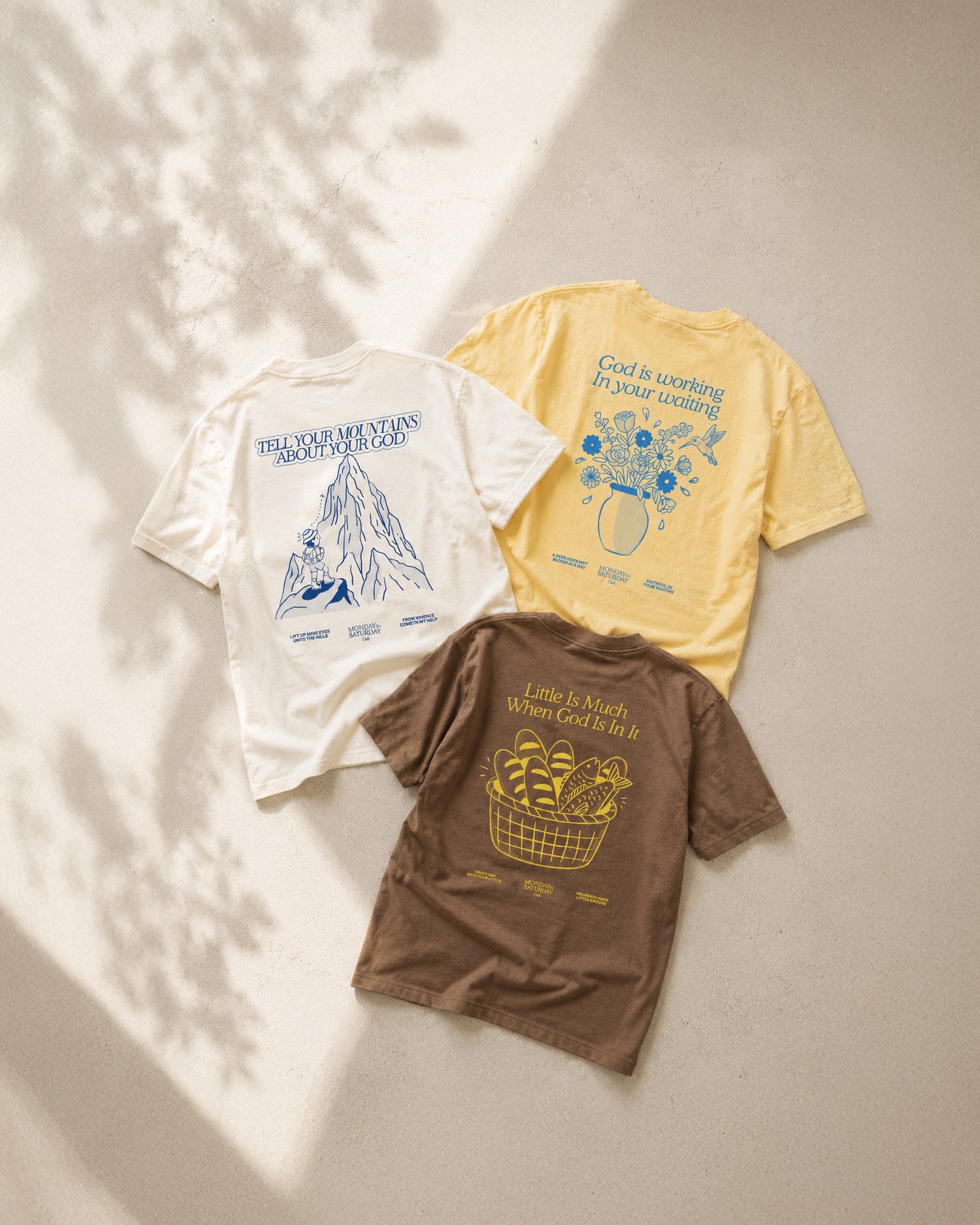 Three MTSC tees laid flat in sunlight